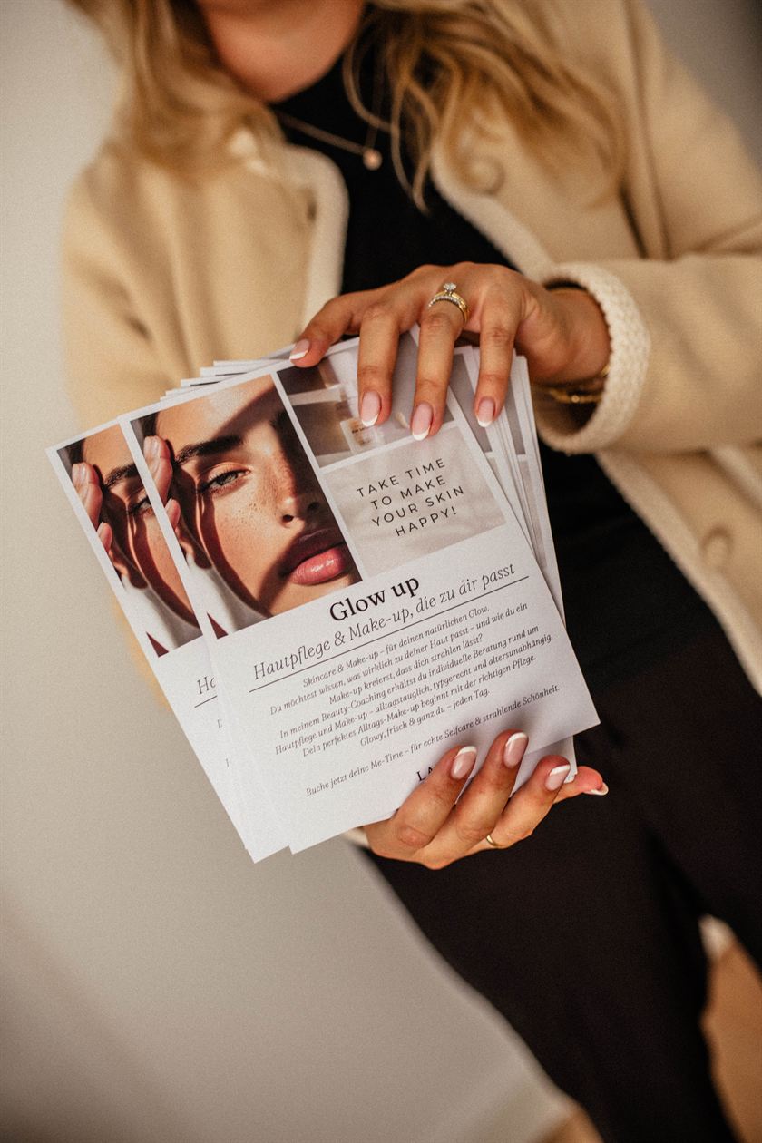 Lara Holzhofer hält Flyer zum Thema Hautpflege und Make-up in den Händen