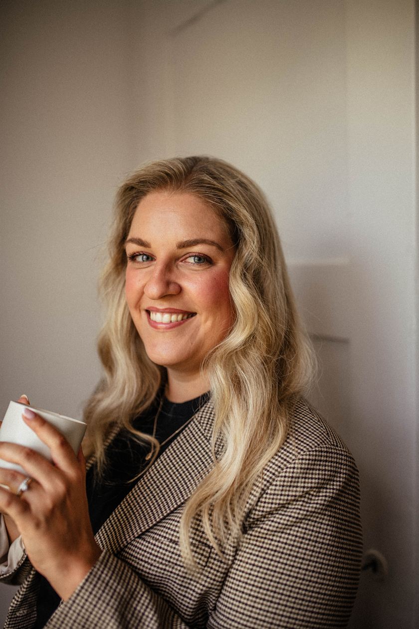 Lara Holzhofer im karierten Blazer, den Blick zur Seite gerichtet
